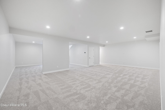 finished below grade area featuring baseboards, light colored carpet, visible vents, and recessed lighting