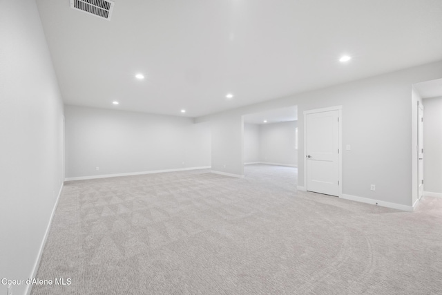 basement with baseboards, light colored carpet, visible vents, and recessed lighting