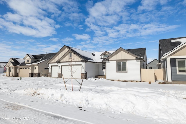 view of front of property with an attached garage, a residential view, fence, and board and batten siding