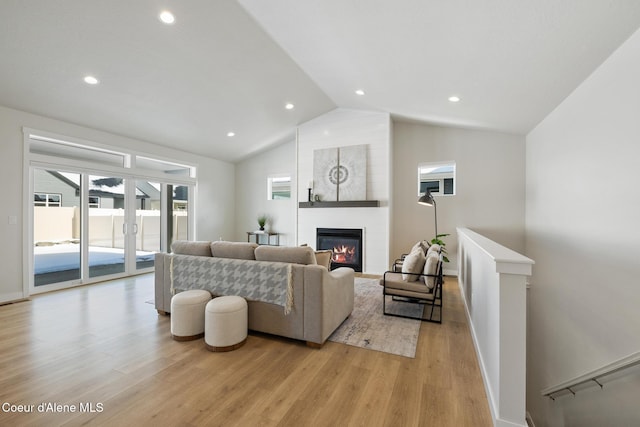 living area with a large fireplace, baseboards, vaulted ceiling, light wood-style floors, and recessed lighting