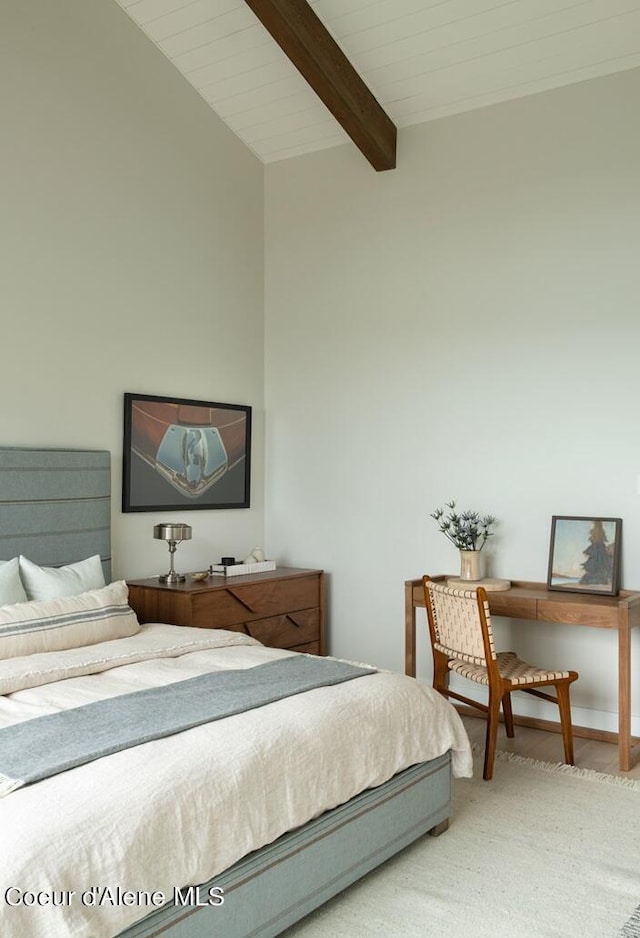 bedroom featuring baseboards, beamed ceiling, and wood finished floors