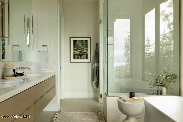 full bathroom featuring double vanity, a freestanding tub, a shower stall, and a sink