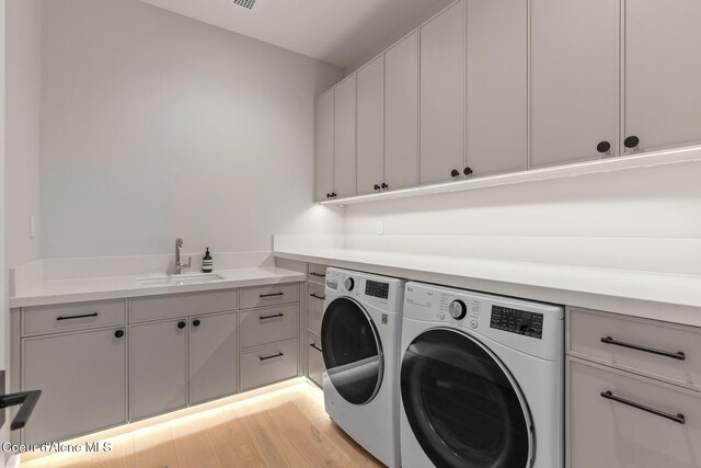 6895 S Gozzer Rd Unit A201, Harrison, ID 83833 - laundry area with washer and dryer, cabinet space, and light wood-style flooring