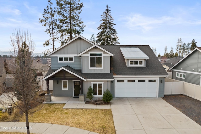 craftsman-style home featuring a shingled roof, board and batten siding, fence, driveway, and a front lawn