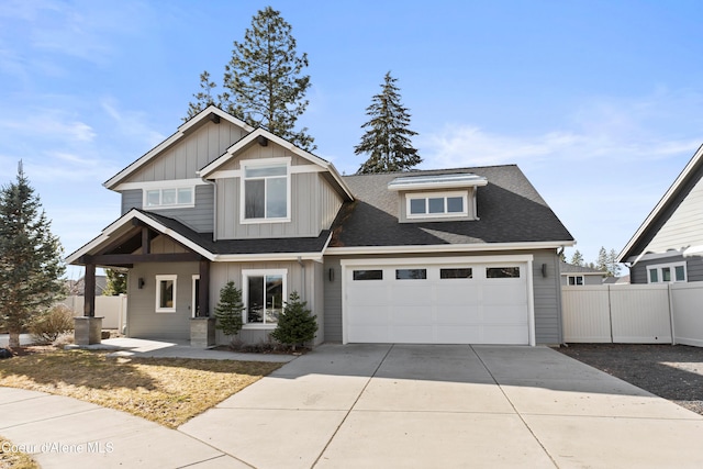 view of front facade with an attached garage, a shingled roof, fence, concrete driveway, and board and batten siding