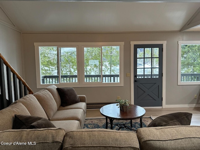 living room featuring vaulted ceiling, a baseboard heating unit, stairway, and wood finished floors