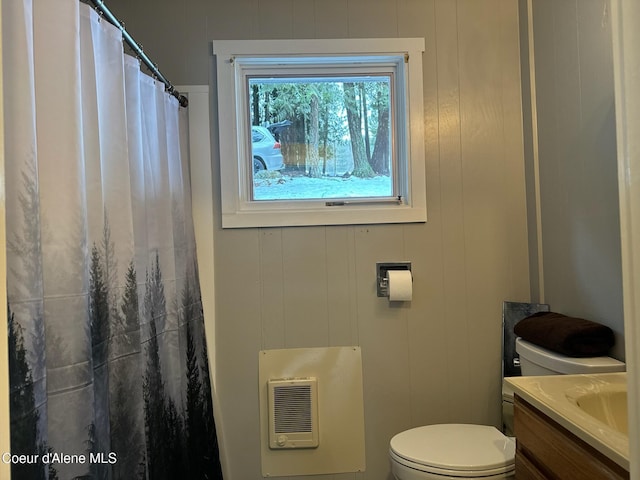 bathroom with a shower with curtain, vanity, toilet, and heating unit