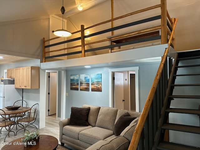 living area with light wood finished floors, stairs, high vaulted ceiling, and beam ceiling