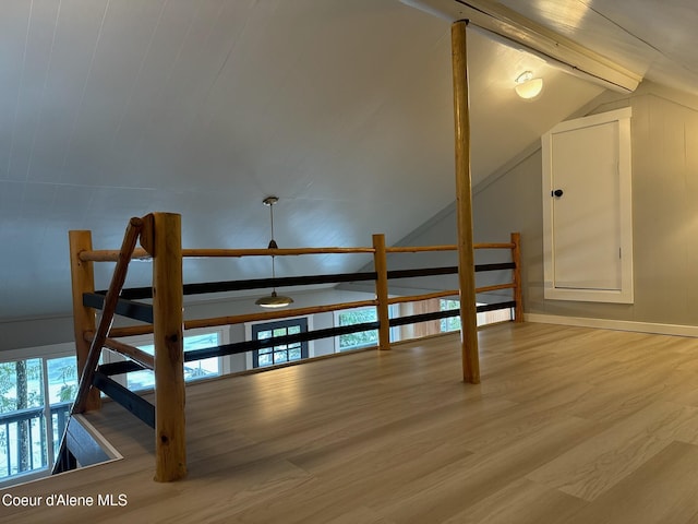 additional living space featuring vaulted ceiling with beams, wood finished floors, and a healthy amount of sunlight