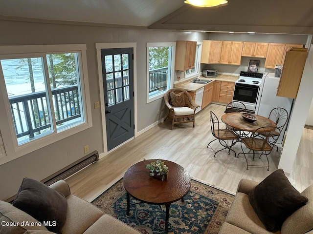 kitchen featuring light wood-type flooring, dishwasher, range with electric stovetop, and light brown cabinetry