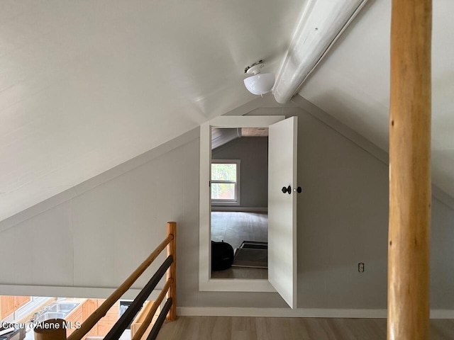 bonus room featuring vaulted ceiling with beams and wood finished floors