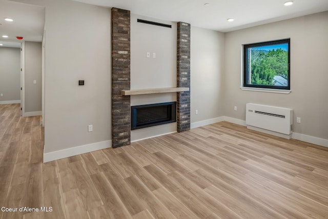 unfurnished living room with light wood finished floors, a fireplace, and baseboards