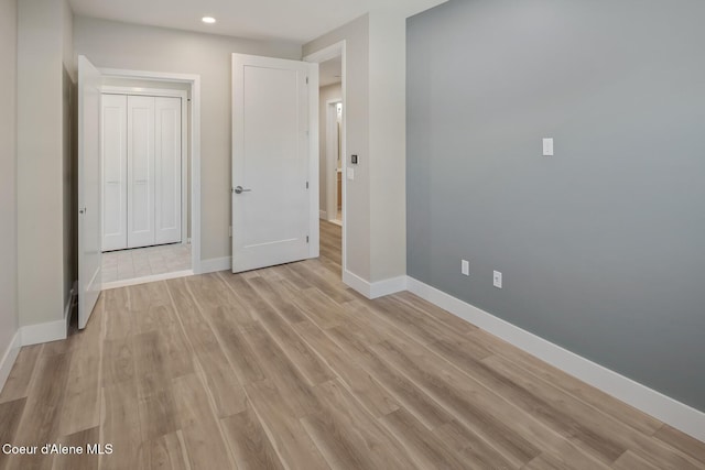 unfurnished bedroom featuring light wood-style floors and baseboards