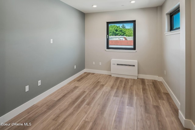 empty room featuring light wood-type flooring, baseboards, and recessed lighting