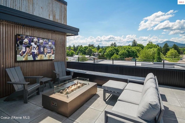 view of patio with a mountain view and an outdoor living space with a fire pit