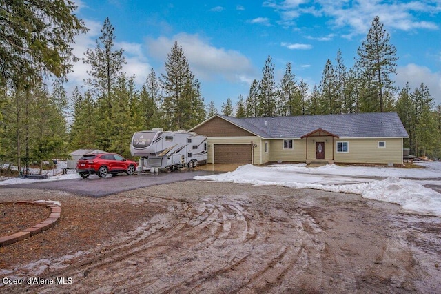 ranch-style house with aphalt driveway and an attached garage