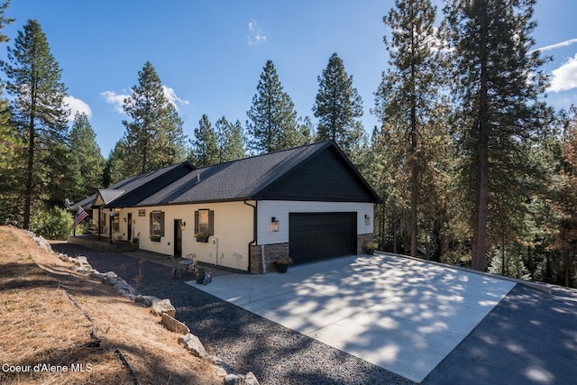 view of property exterior featuring a garage, stone siding, and concrete driveway