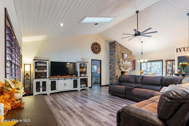 living area featuring a skylight, wooden ceiling, dark wood-style floors, high vaulted ceiling, and ceiling fan with notable chandelier