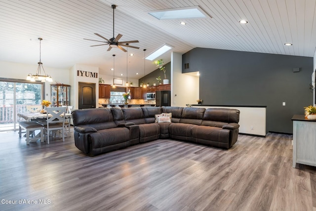 living area featuring a skylight, wood ceiling, high vaulted ceiling, and wood finished floors