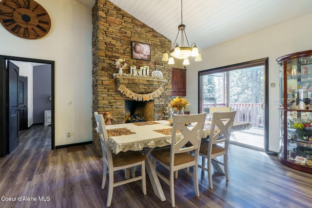 dining room with baseboards, a fireplace, a chandelier, and wood finished floors