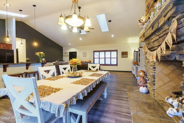 dining space featuring lofted ceiling with skylight and dark wood-type flooring