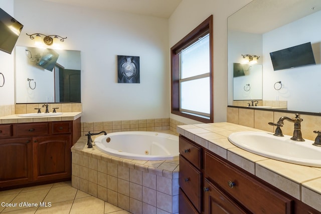 bathroom featuring a tub with jets, two vanities, a sink, and tile patterned floors