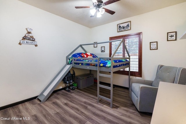 bedroom featuring ceiling fan, baseboards, and wood finished floors