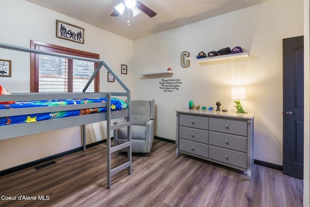 bedroom with wood finished floors, visible vents, and baseboards