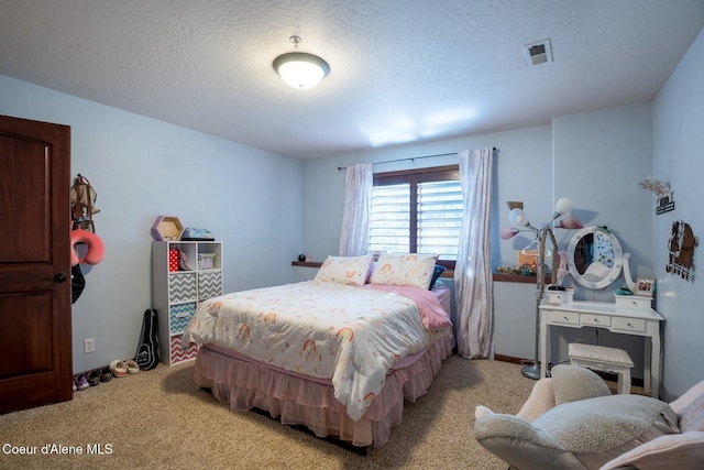 carpeted bedroom featuring a textured ceiling, visible vents, and baseboards