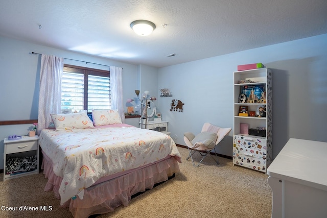 bedroom with carpet floors, visible vents, a textured ceiling, and baseboards