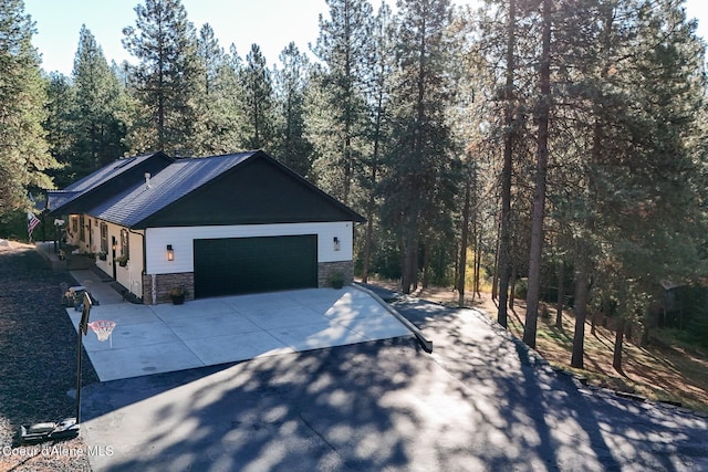 view of home's exterior with an attached garage, driveway, and stone siding