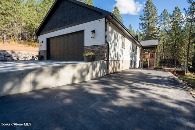 view of home's exterior with stone siding and aphalt driveway