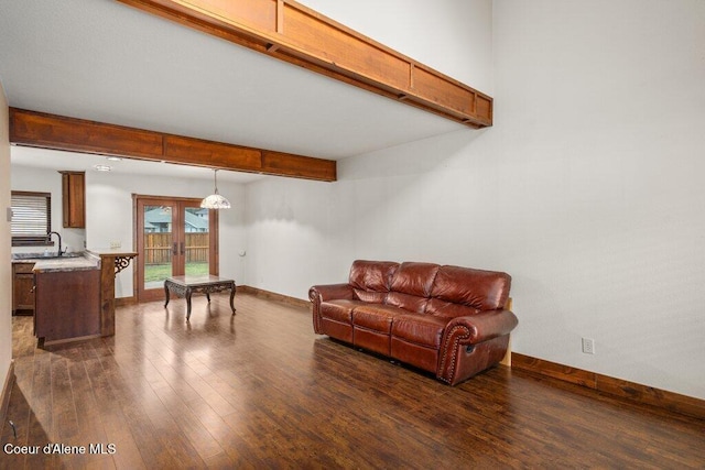 living room with baseboards, dark wood finished floors, beam ceiling, and french doors