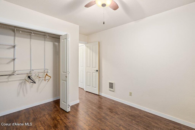 unfurnished bedroom featuring baseboards, visible vents, ceiling fan, wood finished floors, and a closet