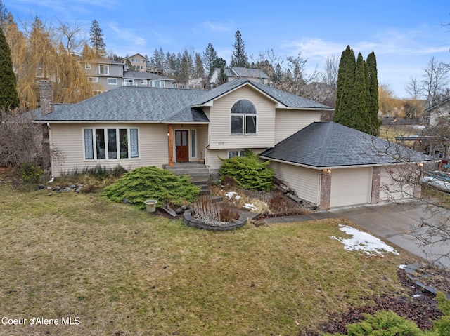 tri-level home with a garage, a shingled roof, driveway, a chimney, and a front yard