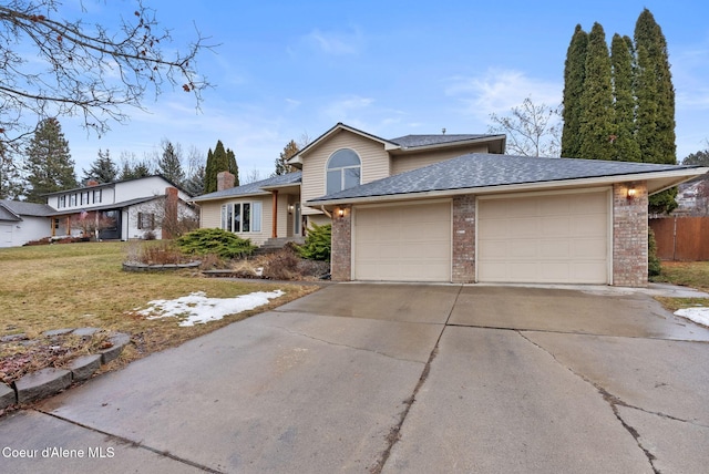 view of front facade with a garage, brick siding, a shingled roof, driveway, and a front lawn