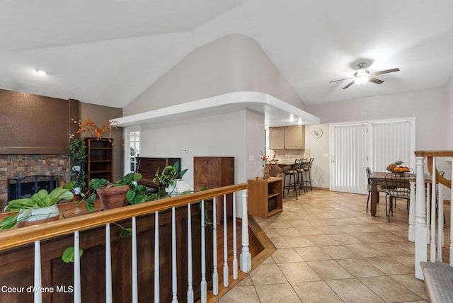 interior space with lofted ceiling, light tile patterned floors, and an upstairs landing