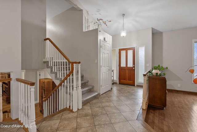 entrance foyer featuring a high ceiling, baseboards, and light wood finished floors