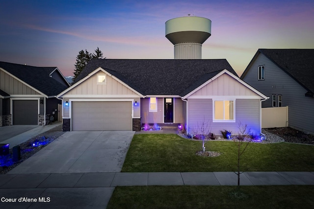 view of front of property featuring concrete driveway, an attached garage, fence, a front lawn, and board and batten siding