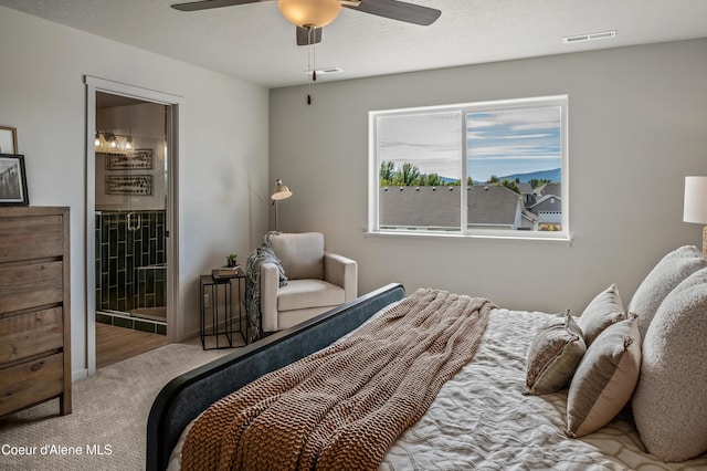 carpeted bedroom with ceiling fan, a textured ceiling, ensuite bath, and visible vents