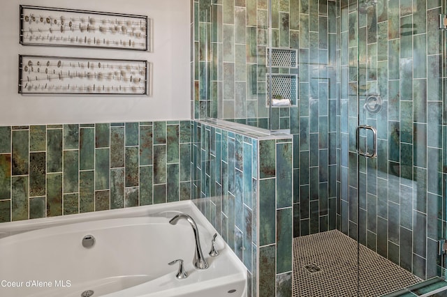 bathroom with a stall shower and a garden tub