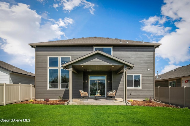 back of property with a patio area, fence, and a yard