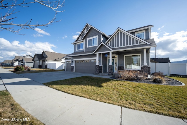 craftsman inspired home featuring driveway, a garage, fence, and a front lawn