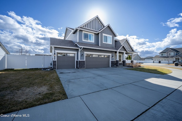 craftsman-style house featuring fence, driveway, a gate, board and batten siding, and a front yard