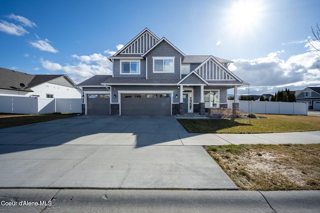 craftsman-style house with an attached garage, fence, a front lawn, and concrete driveway