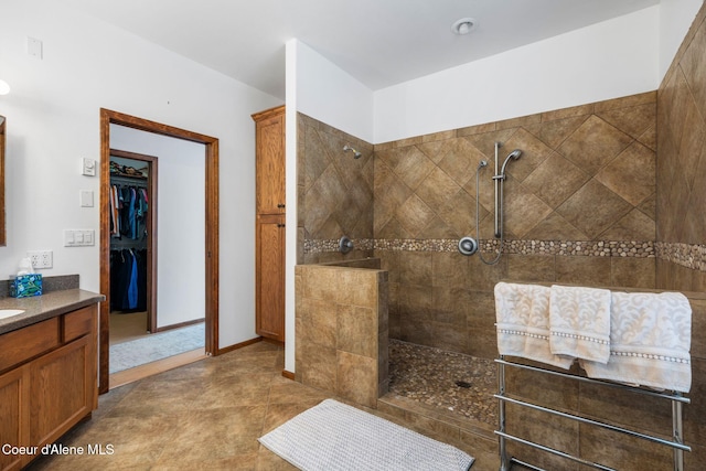 full bath featuring a spacious closet, walk in shower, and vanity