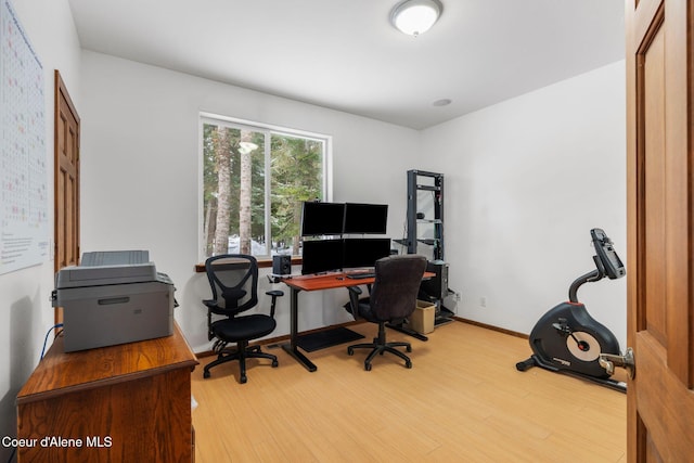 home office with baseboards and wood finished floors