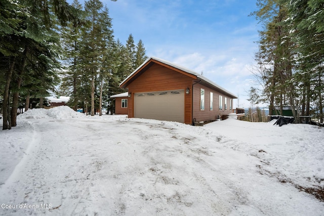 view of snow covered exterior with an attached garage