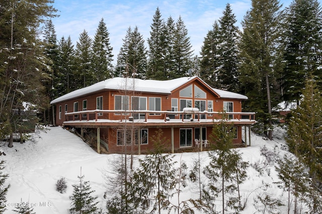 snow covered house with a wooden deck