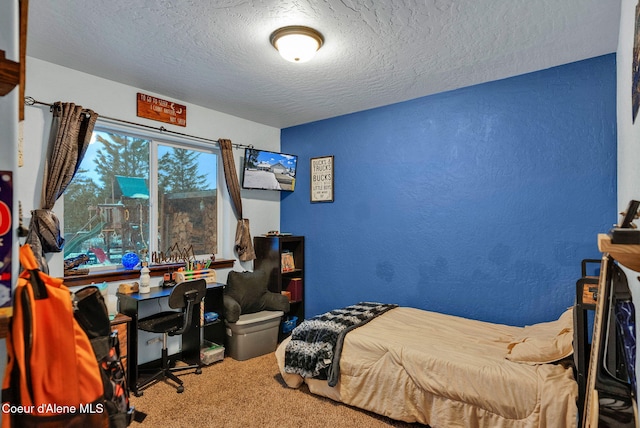 bedroom with a textured ceiling, a textured wall, and carpet